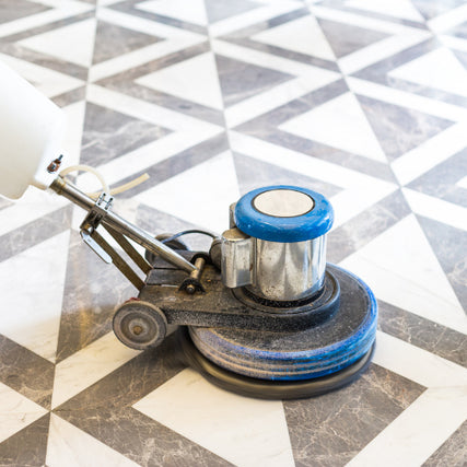Flooring RentalsA floor polisher smoothing a geometric, black-and-white tiled floor. The blue and silver machine contrasts with the clean, polished tiles.